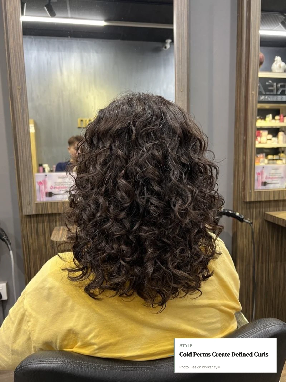 Hair wrapped around perm rods with defined curls visible after a cold perm
