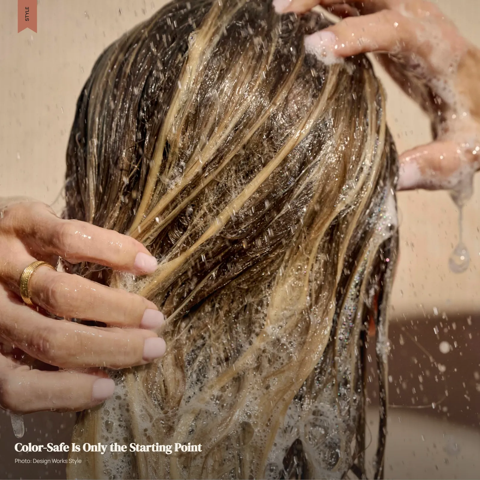 Balayage hair with darker roots being gently washed to maintain color-treated lengths
