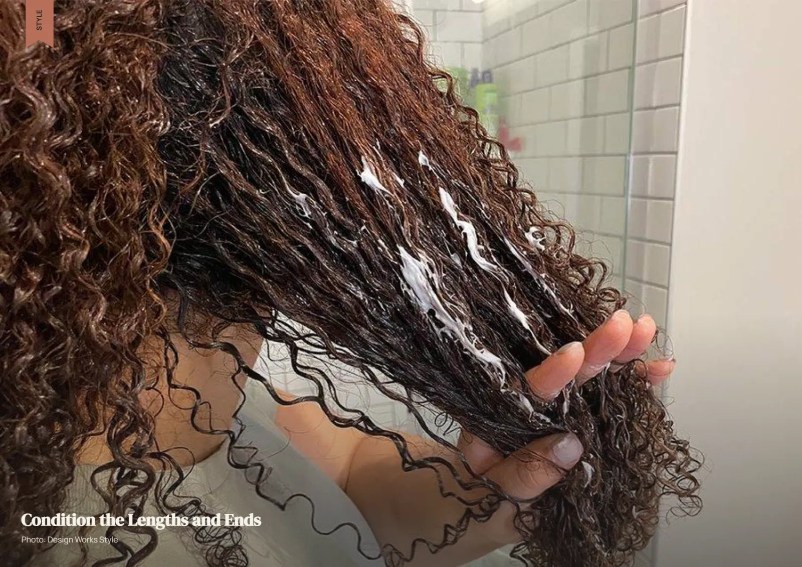 Conditioner being gently applied through the lengths and ends of wet curly hair