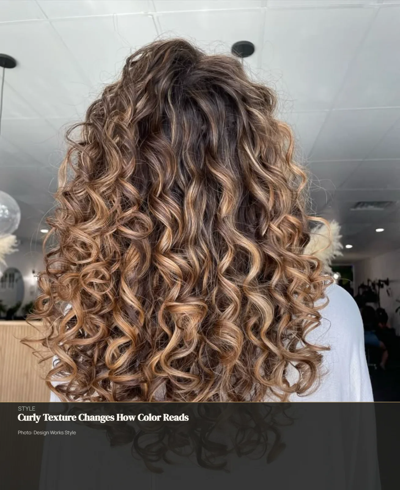 Defined curls with lighter balayage pieces catching light across the curl pattern