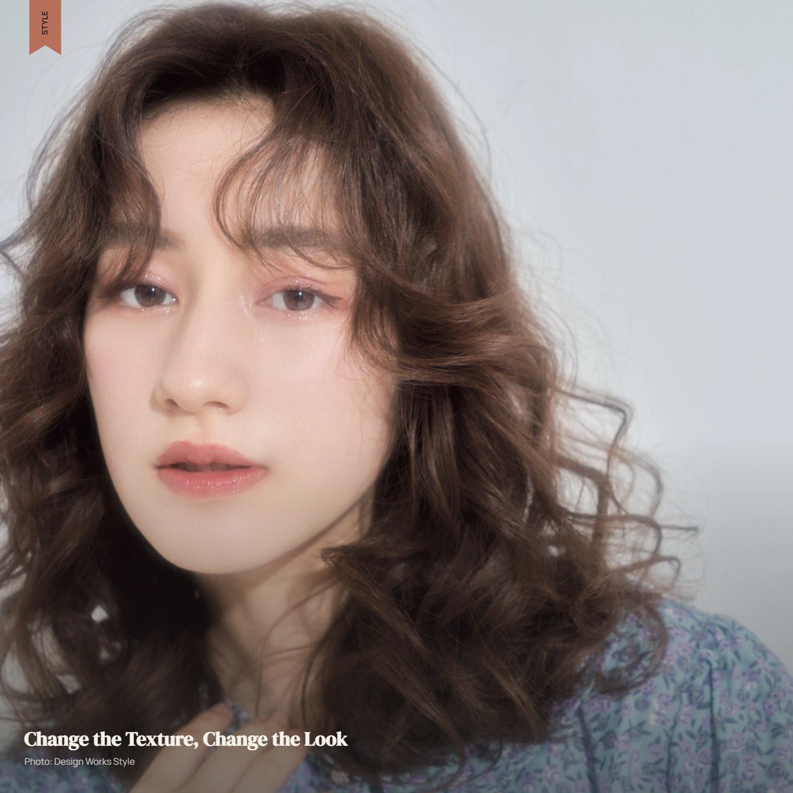 Permed hair with natural-looking waves and defined curls in a soft editorial portrait