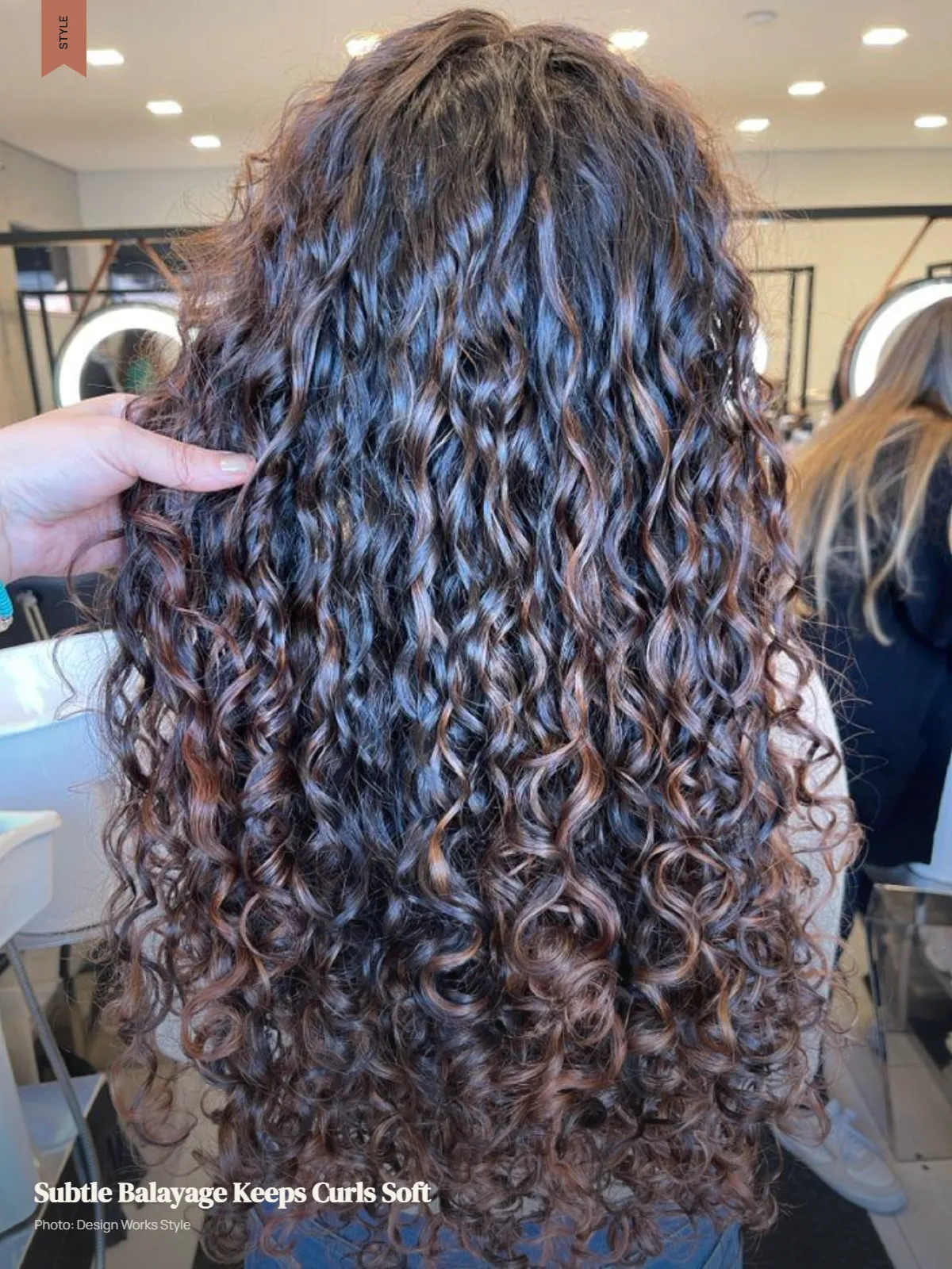 Curly hair with soft low-contrast balayage pieces and a visible darker base