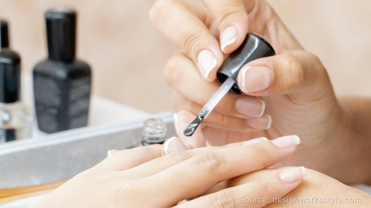 Applying top coat from a bottle to seal a French manicure