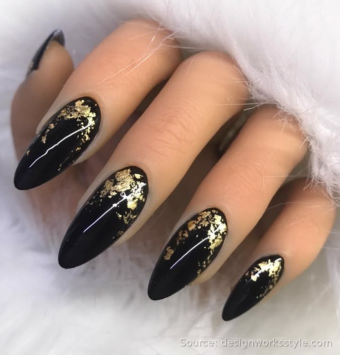 Black stiletto nails with gold foil accents for New Year's Eve