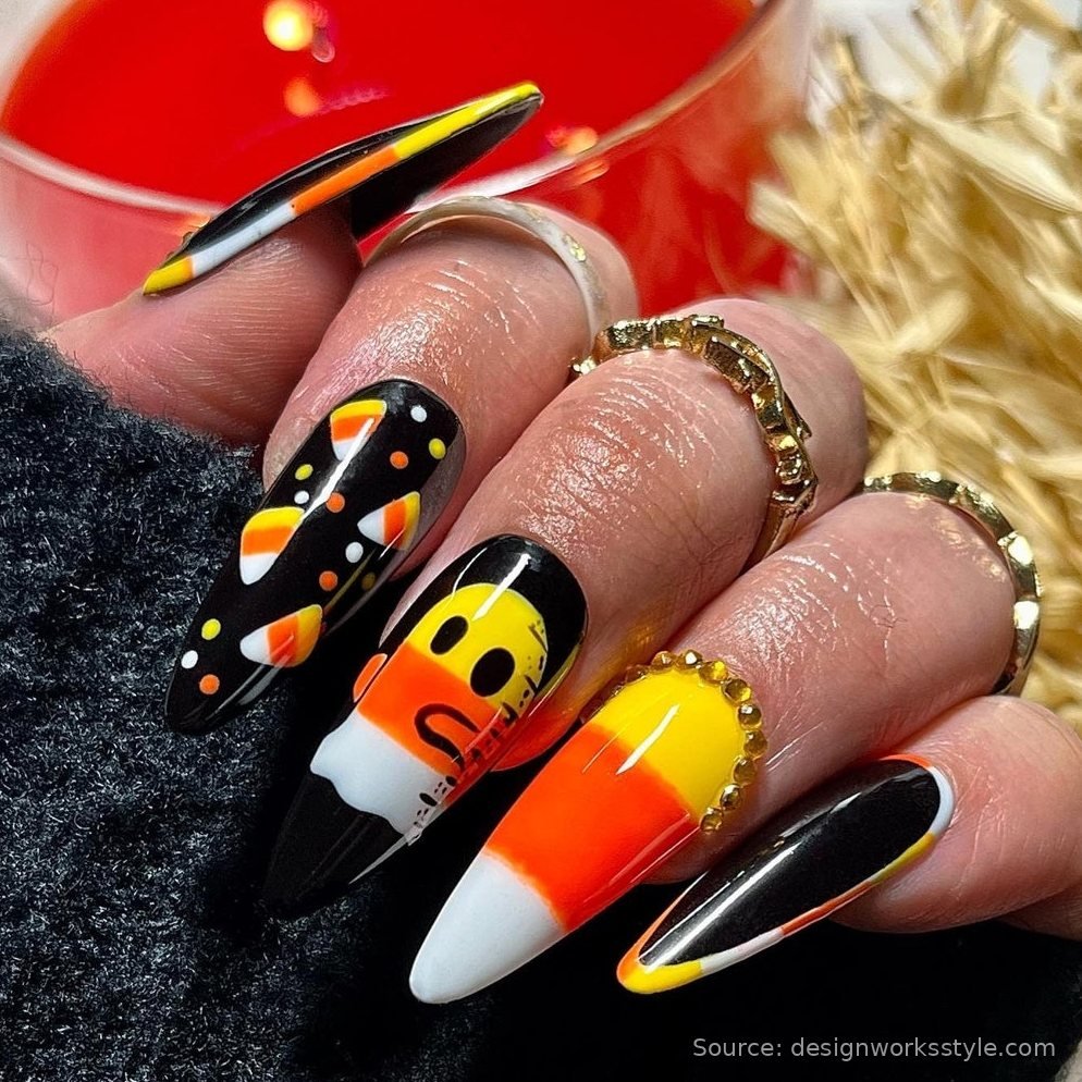 Bold candy corn Halloween nails with yellow orange and white stripes on black