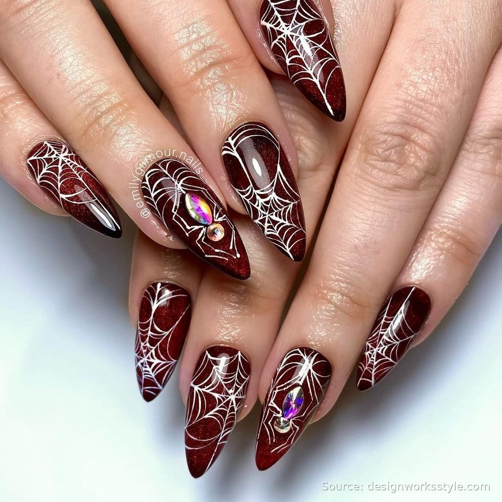 Burgundy cat eye nails with white spiderweb art and crystal spiders