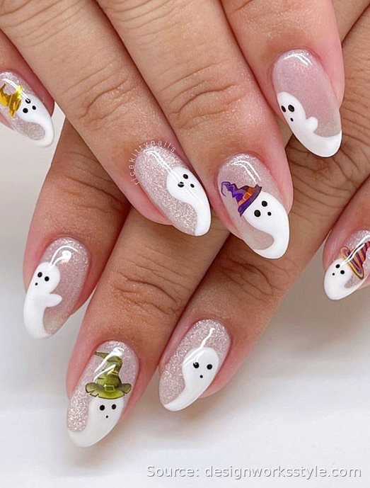 Cute white ghost nail art with tiny witch hats on glittery pink nails