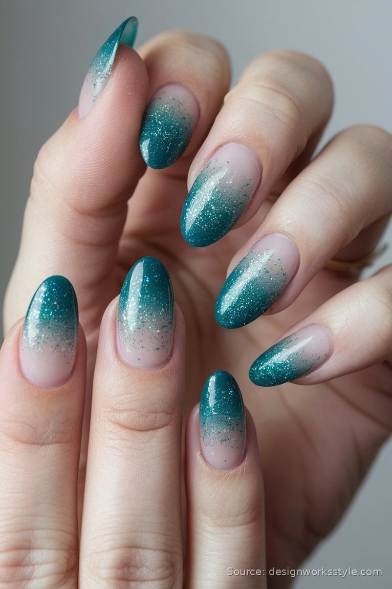 Deep teal glitter ombre winter nails fading over nude almond nails