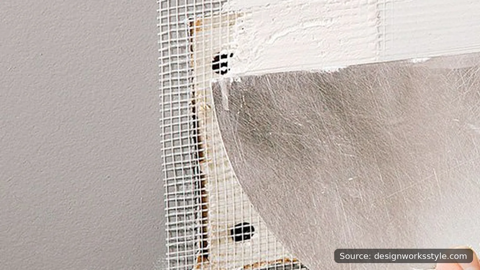 Self-adhesive mesh patch covering a hole in drywall