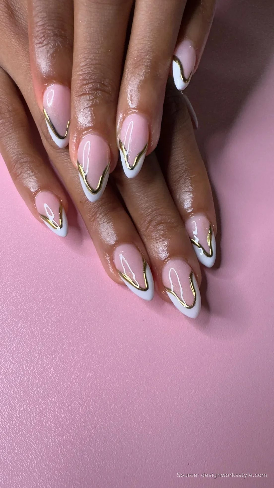 White French tip nails with gold outline on almond nails