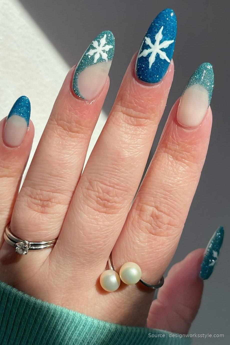 Icy blue glitter French tip winter nails with snowflake art on almond shape
