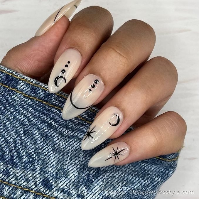 Nude stiletto nails with black micro moons and stars