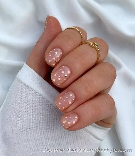 Minimalist gold polka dot nail art on sheer nude Christmas nails