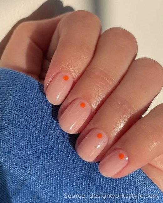 Nude nails with single orange micro dot near the cuticle