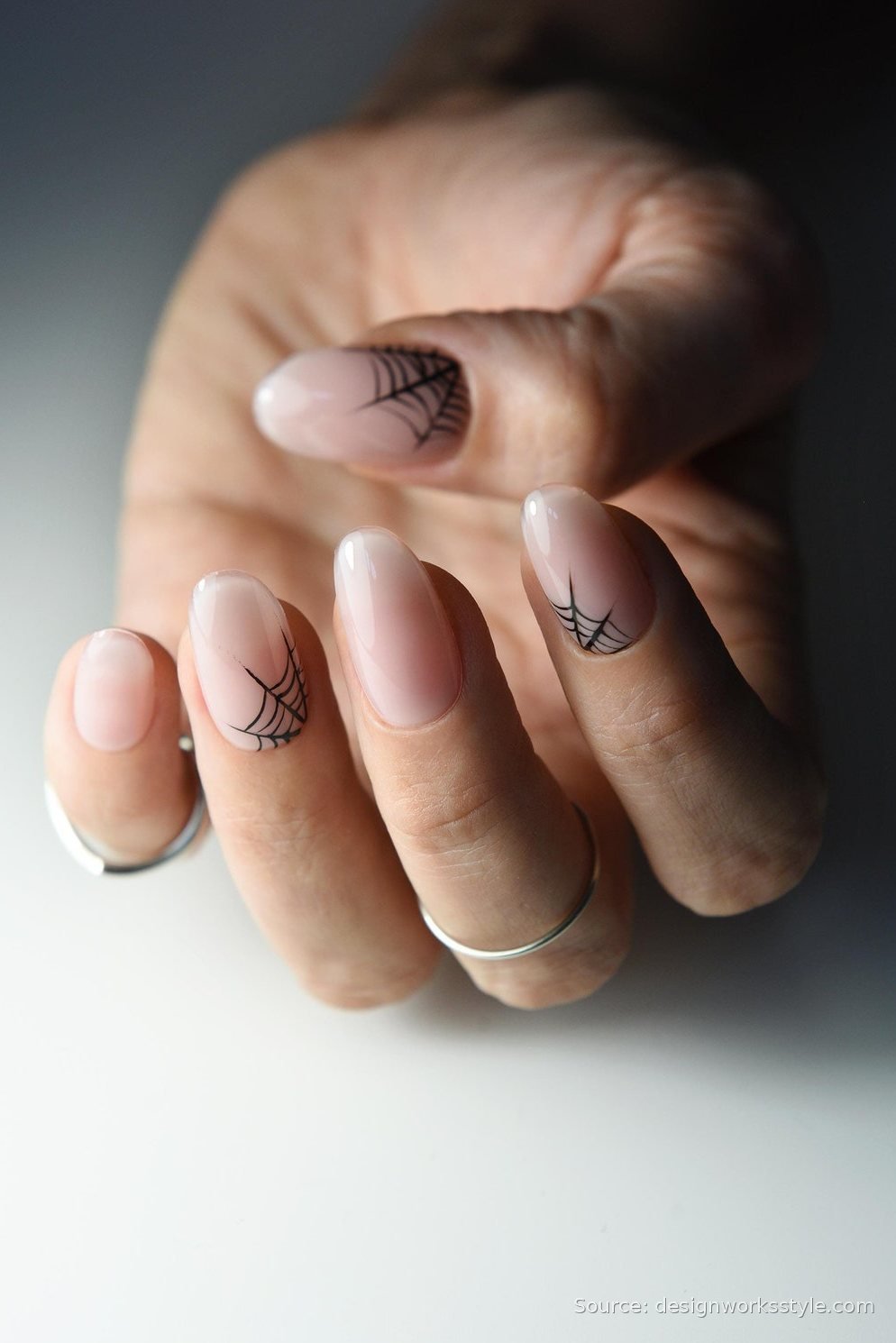 Sheer nude nails with mini black spiderweb corner art