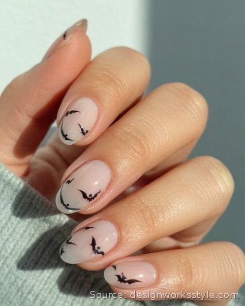 Tiny black bat silhouettes on sheer nude nails