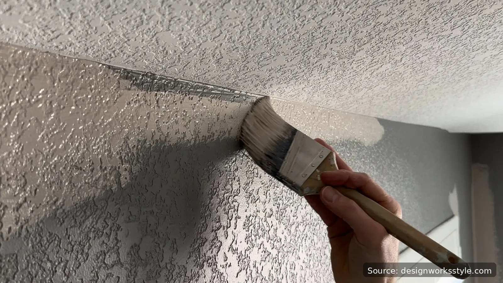 Cutting in paint along a ceiling edge with an angled brush