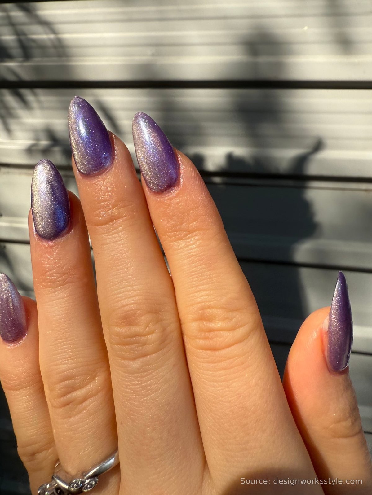 Purple magnetic cat eye nails glowing in sunlight