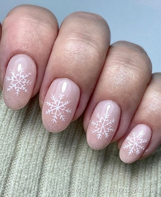 White snowflake accent nail art on sheer nude Christmas nails
