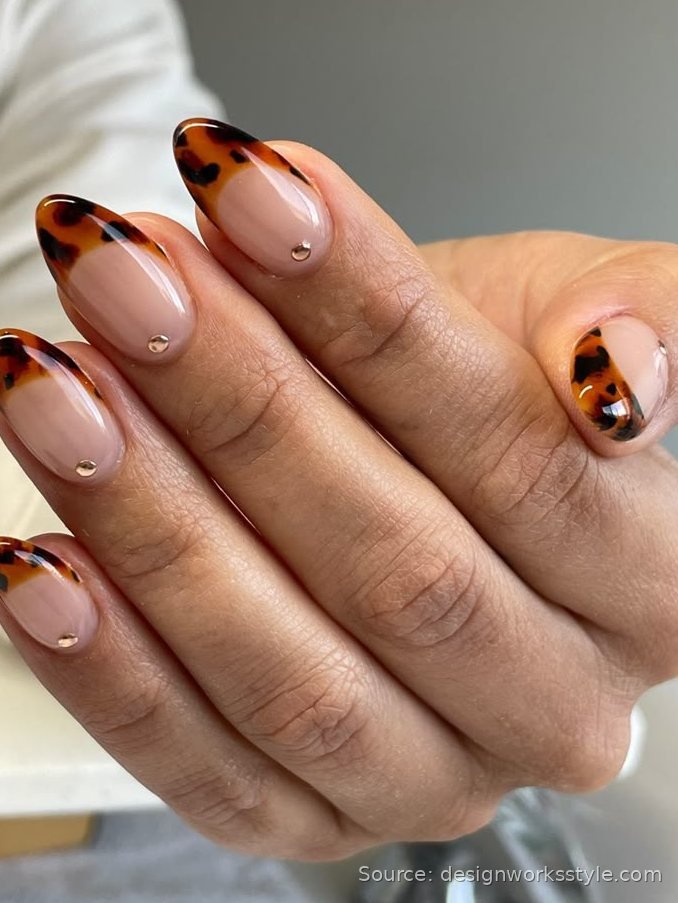 Tortoiseshell French tip nails with gold dot accents on nude nails