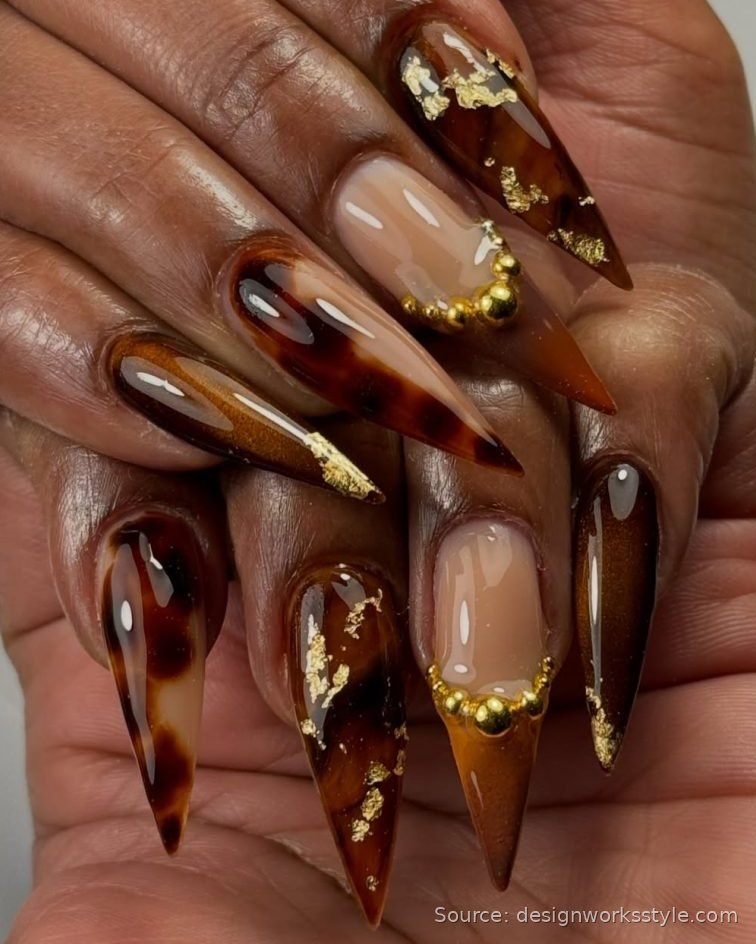 Tortoiseshell November nails with gold foil and gold bead accents on stiletto nails